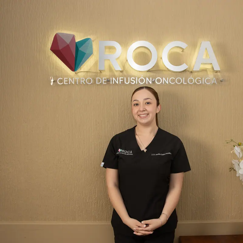 Enfermera de ROCA recibiendo a los pacientes bajo el logotipo del centro